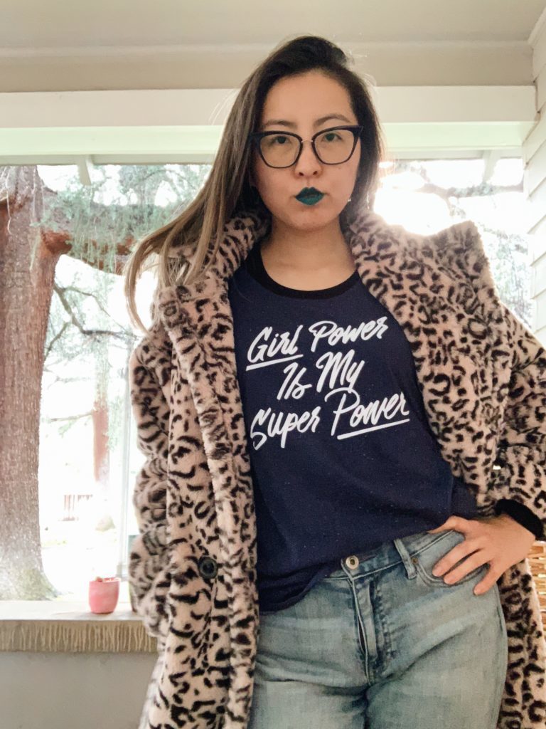 Alice wearing a faux fur coat over a geeky T-shirt and jeans